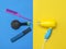 Yellow-blue hair dryer with hair care accessories on a colorful background.