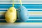 Yellow and blue hanged Easter eggs on striped background