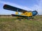 Yellow and blue old biplane plane with a single piston engine and propeller