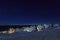 Yellow, blue, red and green inuit houses covered in snow at the fjord under the starlight sky, Nuuk city, Greenland