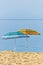 Yellow and blue sunshades on sandy beach against blue sky in Sithonia