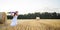 Yellow blue Ukrainian flag in hands of girl running on mangled field of wheat. Happy child with the flag of Ukraine. Independence