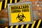 Yellow board in front of a clinker wall with biohazard corona virus