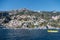 Yellow boat on the sea near a lot of buildings on the hill in Sorrento, Italy