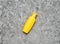 A yellow bottle of shampoo on a gray concrete table. Trend of minimalism. Top view. Products for the shower. Space for text