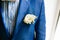 Yellow boutonniere pinned to a grooms jacket