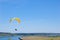 Yellow bright Paraglider in blue sky above the river and riverside. Bird`s eye panorama. Tom river. Tomsk city, Russia