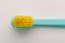 Yellow bristle toothbrush macro shot on white background.