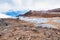 A yellow / brown lava field, with mountains in the background,