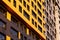 Yellow-brown modern ventilated facade with windows. Fragment of a new elite residential building or commercial complex. Part of
