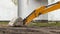 The yellow bucket of the excavator is stuck in the ground