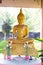 A yellow Buddha image, a Buddhist believer, is placed in a pavilion with lotus flowers