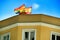 Yellow building facade with rainbow and spanish flag on top