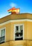 Yellow building facade with rainbow and spanish flag on top