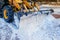 Yellow bulldozer clears the street after a heavy natural snowfall. Preparing for Christmas. Sunny frosty day. Close-up.