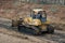 Yellow Bulldozer scooping dirt at a construction site