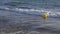 Yellow buoy floating in sea water slow motion. Sea buoy floating on water waves.