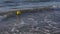 Yellow buoy floating on shallow in sea with waves, 120fps slow motion concept