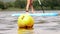 A yellow buoy is floats in a lake, on a background young woman rides on a paddleboard