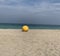 Yellow buoy washed up on the shore of a beach