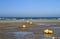 Yellow buoys on the beach at low tide