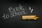 Yellow bus and phrase `Back to school` on chalkboard, top view