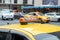 Yellow cab with taxi sign on the roof parked on the city street waiting for passengers to pick up.The taxi is parked on the street