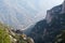 Yellow cabin of mountain aerial cableway goes up to Monastery of Montserrat. Misty mountain massif, abyss and canyon on backgro