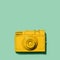 Yellow camera laying on a green background