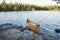 Yellow canoe on rocky shore of northern Minnesota lake at sunrise during autumn