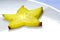 Yellow carambola slice on white plate