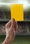 Yellow card with hand from referee giving a penalt