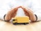 Yellow cargo delivery truck miniature protected by hands