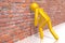 Yellow cartoon character banging head against the wall - 3D illustration