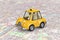 Yellow Cartoon Taxi Car over Abstract City Map. 3d Rendering