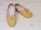 Yellow casual leather flat shoes on wooden background