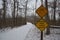 Yellow caution bridge slippery when wet sign on bridge with snow