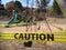 Yellow caution tape around playground during coronavirus pandemic.