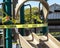 Yellow caution tape in english and spanish barring access to playgound equipment at a park due to coronavirus pandemic