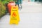 Yellow caution wet floor sign board on floor near swimming pool