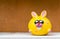 Yellow ceramic bunny over orange wall background