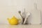 Yellow ceramic teapot and kitchen utensil.