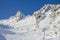 Yellow chair lift on a background of snowy Caucasus mountains in winter. Ski resort Rosa Khutor