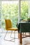 Yellow chair next to a table in a dining room interior with a terrace