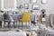 Yellow chair next to a table in a grey dining room interior