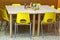 Yellow chairs with a toy over the desk inside the nursery