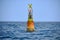 Yellow channel marker buoy floating in the sea - lighthouse nautical