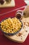 Yellow chickpeas lie in an oriental plate on a wooden spice board