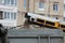 A yellow city sweeper cleans the road from dirt that enters the body by the conveyor