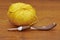 A yellow clew with a crochet hook on the table